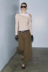 Camiseta de manga larga gris melange con cuello redondo y diseño asimétrico que simula una doble camiseta, con una capa inferior blanca visible en el cuello y el bajo.