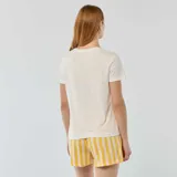 Conjunto de pijama compuesto por una remera blanca de manga corta con pequeño estampado de sol y la frase 'Sunshine' en el pecho, y un short a rayas verticales en tonos amarillo y rosado con elástico en la cintura y etiqueta con la palabra 'Love.'.