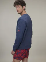 Sweater verde militar de cuello redondo y manga larga con detalle de bolsillo con solapa en la manga izquierda.