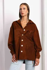 Camisa de corte amplio y silueta relajada, color negro, de manga larga con cuello clásico, botones frontales y puños anchos. Confeccionada en gamuza.
