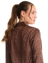 Camisa de satén labrado color marrón con estampado animal print tonal. Presenta cuello con solapa, manga larga y cierre frontal con botones.