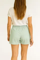 Short de tiro alto confeccionado en mezcla de lino y viscosa. Presenta un corte holgado, cintura elástica y bolsillos frontales con detalle de costuras horizontales.