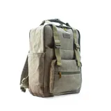 Mochila matera y porta notebook en tela canvas de color marrón, con diseño funcional que incluye bolsillo frontal con cierre, correas ajustables, manija superior y detalles de tiras de lona con hebillas metálicas.