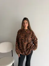 Buzo de peluche con estampado animal print de leopardo, de corte oversize, cuello redondo y mangas largas.