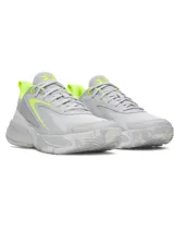 Championes Under Armour Lockdown 8, color gris con detalles en verde fluo. Parte superior de malla transpirable con superposiciones de cuero, entresuela de EVA y suela exterior de caucho macizo.
