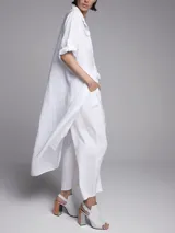 Vestido camisero largo color gris topo, de lino, con cuello camisero, mangas 3/4 con trabillas y bolsillos de parche en el pecho. Incluye cinturón de soga cruda con borlas.