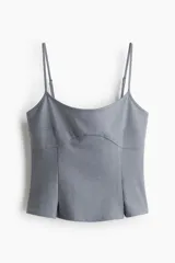 Top entallado color gris, con breteles finos ajustables, escote curvo y costura bajo el busto que da forma a un peplum sutil con pliegues invertidos en el bajo.