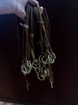 Gargantilla de cuero marrón con dije circular dorado.