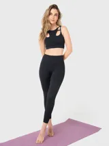 Calza deportiva de tiro alto y largo al tobillo, confeccionada en tejido técnico elástico de color negro. Presenta un diseño liso sin bolsillos, ideal para actividades físicas.
