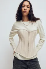 Top estilo corset de escote corazón y hombros descubiertos, con varillas interiores para estructura. Presenta cierre frontal con ganchos metálicos y ajuste posterior mediante cordones cruzados.
