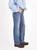 Jean de corte recto y tiro medio, en color azul clásico con efecto de lavado desgastado. Cuenta con cierre frontal y bolsillos laterales.