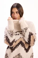 Buzo de tejido de punto con cuello alto, diseño de estampado geométrico en tonos beige, marrón y crema, de corte holgado y mangas largas.