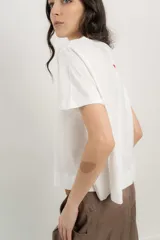 Remera blanca de algodón orgánico, con escote en V, mangas cortas y corte A-line. Cinta aplicada en la espalda con bordado de palmera.