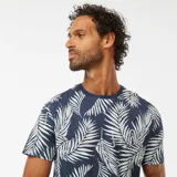 Camiseta de manga corta azul con estampado de hojas de palmera blancas.