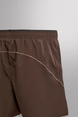 Short de running color marrón, confeccionado en tejido técnico elástico con forro interior. Cuenta con cintura elástica ajustable, bolsillos laterales con cierre de cremallera oculto y aberturas en las perneras.