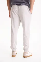 Pantalón de jogging negro sin friza, con puños elastizados en los tobillos y cordón ajustable en la cintura.