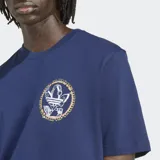 Remera de manga corta color azul marino con cuello redondo y corte holgado. Presenta un gráfico circular en el pecho con un diseño estilizado del logo del Trifolio en blanco y detalles dorados/amarillos.