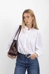 Cartera tipo shopper de cuero genuino marrón con panel central de textura símil cocodrilo y herrajes metálicos plateados.