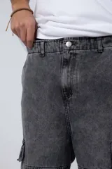 Pantalón jean cargo de corte oversize y tiro medio, con bolsillos laterales tipo cargo y costuras reforzadas en las rodillas.