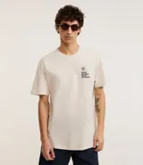 Remera de algodón color crema, de corte recto, con cuello redondo y mangas cortas. Estampa en el pecho con lettering "vento na cara, solto no mundo".