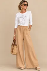 Pantalón de lino color tostado, de corte amplio y silueta recta, con cintura elastizada fruncida.