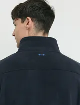 Campera de micropolar color verde oscuro, con cuello alto, cierre frontal completo, bolsillos laterales y un bolsillo con cierre en el pecho.