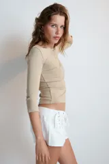 Camiseta blanca de manga larga con cuello panadero y cierre frontal de botones, corte slim fit.