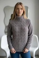 Sweater de cuello alto tipo polera, confeccionado en tejido de chenille con textura suave y diseño de trenzas verticales. Presenta puños y ruedo acanalados.