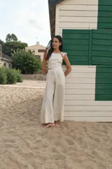 Pantalón palazzo color coral de lino con cintura alta y bolsillos laterales.