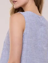 Blusa sin mangas de algodón liviano con diseño de rayas verticales en tonos beige y blanco, escote redondo, abotonadura frontal con botones rústicos y detalle de nudo para anudar en la cintura.