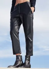 Pantalón sastrero negro de ecocuero con botamanga irregular, bolsillos delanteros y bolsillos ojal en la espalda.