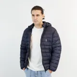 Campera puffer de nylon color azul marino, liviana y con capucha desmontable. Presenta cierre frontal y logo bordado en el pecho.