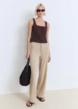 Pantalón de punto fino en color beige, con diseño recto y largo. Cuenta con cintura elástica con cordón ajustable.