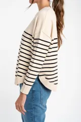 Sweater color crema con rayas horizontales finas color marrón claro, de corte holgado y mangas largas.