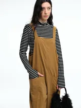 Mono largo de pana color verde oscuro, con breteles finos y silueta relajada de pierna amplia.