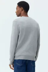 Buzo de punto fino con cuello redondo y diseño de corte estándar. Presenta terminaciones acanaladas en el cuello, los puños y el ruedo.