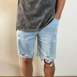 Bermuda de jean celeste con roturas y terminación desflecada.