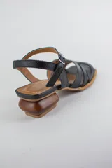 Sandalias doradas con capellada de cuero metalizado y malla, puntera cuadrada, tira ajustable al tobillo y taco geométrico de madera.