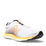 Championes de running New Balance modelo 520, color blanco con detalles en negro y naranja. Presentan capellada de malla transpirable, logo lateral en naranja y entresuela con diseño texturizado en degradado amarillo.