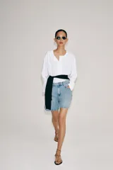 Shorts denim de tiro alto y corte relaxed, confeccionados en tejido vaquero celeste claro. Presentan trabillas en la cintura, diseño de cinco bolsillos, pliegues frontales y cierre con cremallera y botón metálico.