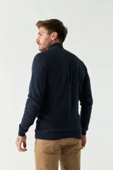 Campera tejida azul marino con cierre frontal, cuello alto y mangas largas.