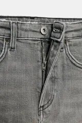 Jeans de tiro alto color marrón oscuro con acabado lavado, corte recto/flare y bajo cropped sin costuras. Presenta cinco bolsillos y cierre frontal con cremallera y botón metálico.