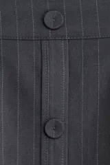 Short pollera de sarga gris oscuro con diseño tableado, rayas finas verticales y botones forrados decorativos en la parte delantera.