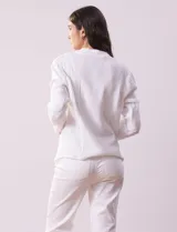 Chaqueta color crema de algodón con bolsillos simulados y terminación desflecada.