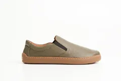 Championes slip-on color verde militar, con capellada de cuero graneado y suela de goma marrón. Presentan elásticos laterales para un calce cómodo y rápido, y costuras decorativas en contraste.