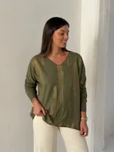 Sweater de punto color verde oliva con estampado de pinceladas doradas brillantes, escote en V y mangas largas con diseño holgado.