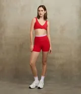 Bermuda deportiva de tiro alto color rojo, con cintura elástica en contraste color rosa claro. Confeccionada en tejido de microfibra elástica, diseñada para actividades físicas.