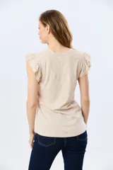 Remera de algodón color beige con sutil estampado, cuello redondo y mangas cortas con doble volado aportando volumen y un diseño femenino.