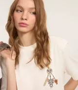 Remera de algodón color crudo con cuello redondo y mangas cortas. Estampa frontal pequeña y estampa trasera grande de Tom y Jerry.