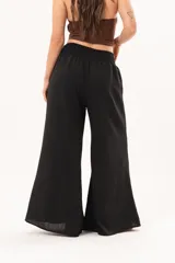 Pantalón palazzo negro de corte ancho, con cintura elástica fruncida y diseño fluido.